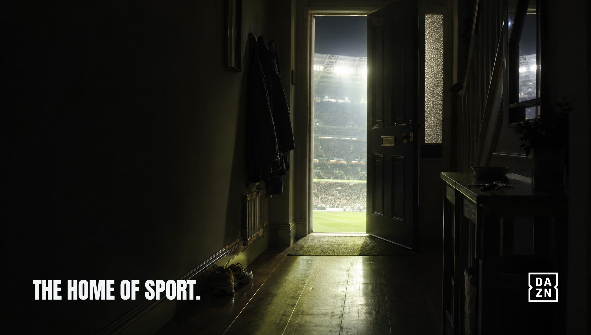 A front door ajar onto a floodlit stadium